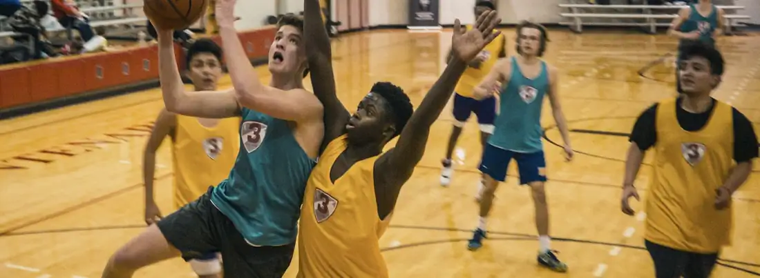 Basketball players competing in an indoor gym game