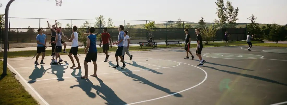 Young players on an outdoor basketball court in summer
