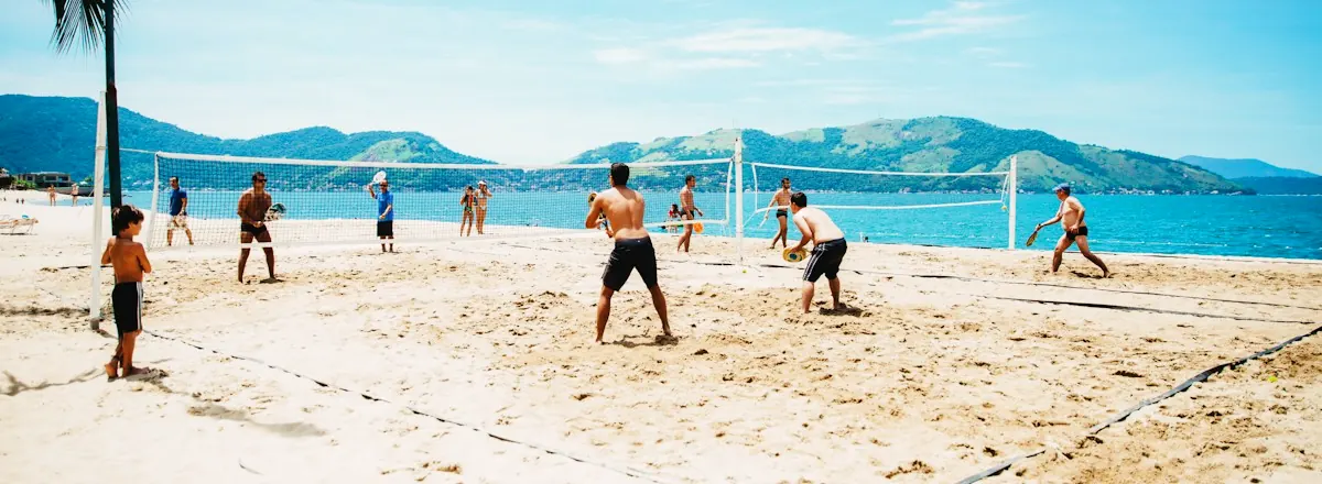 Summer volleyball on a sunny beach by the sea with mountains behind